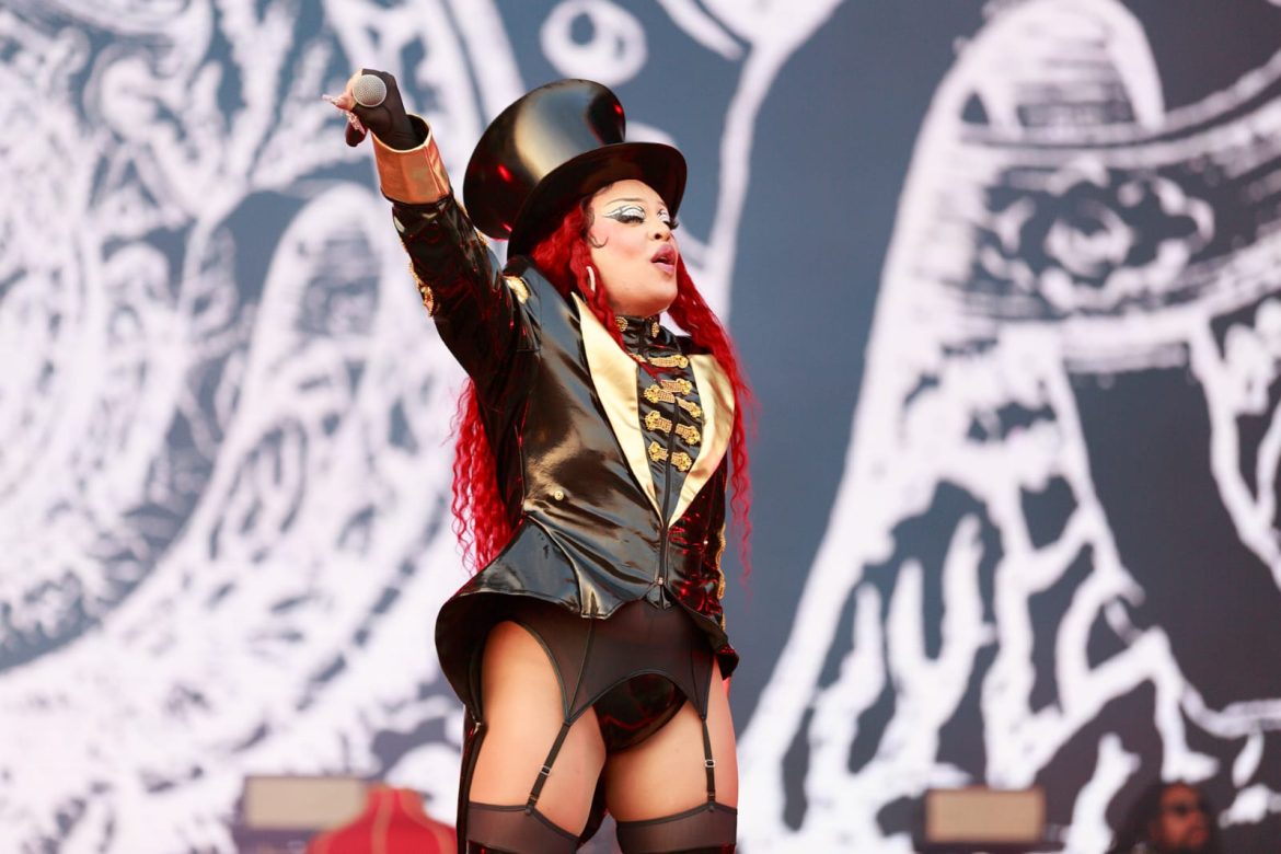 Gloria Groove levanta microfone para o públo enquanto se apresenta no Palco Mundo