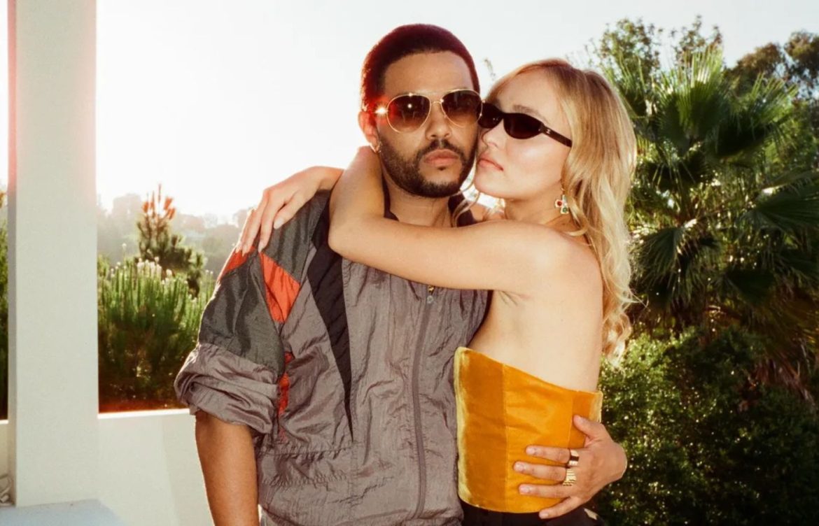 The Weeknd e Lily-Rose Depp abraçados em um fundo de plantas do backstage da série The idol, da HBo Max.