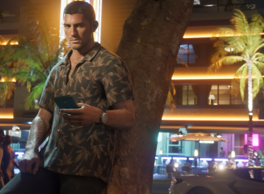 Personagem masculino de GTA 6 encostado em uma árvore no coração vibrante de Vice City, à noite, com expressão séria e celular na mão, em meio ao clima tropical e luzes neon da cidade.