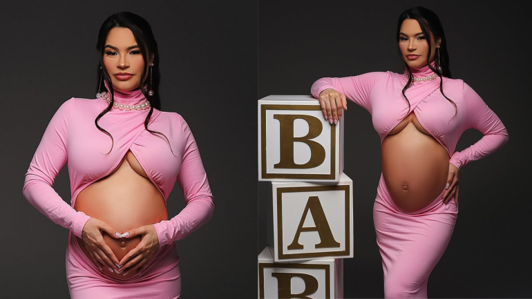 aissa Barbosa grávida posa para ensaio fotográfico usando vestido rosa justo com recorte na barriga. Em uma das fotos, ela forma um coração com as mãos sobre o ventre; na outra, apoia a mão em blocos decorativos que formam a palavra "BABY". O cenário tem fundo preto e iluminação suave, destacando a silhueta da gestante.
