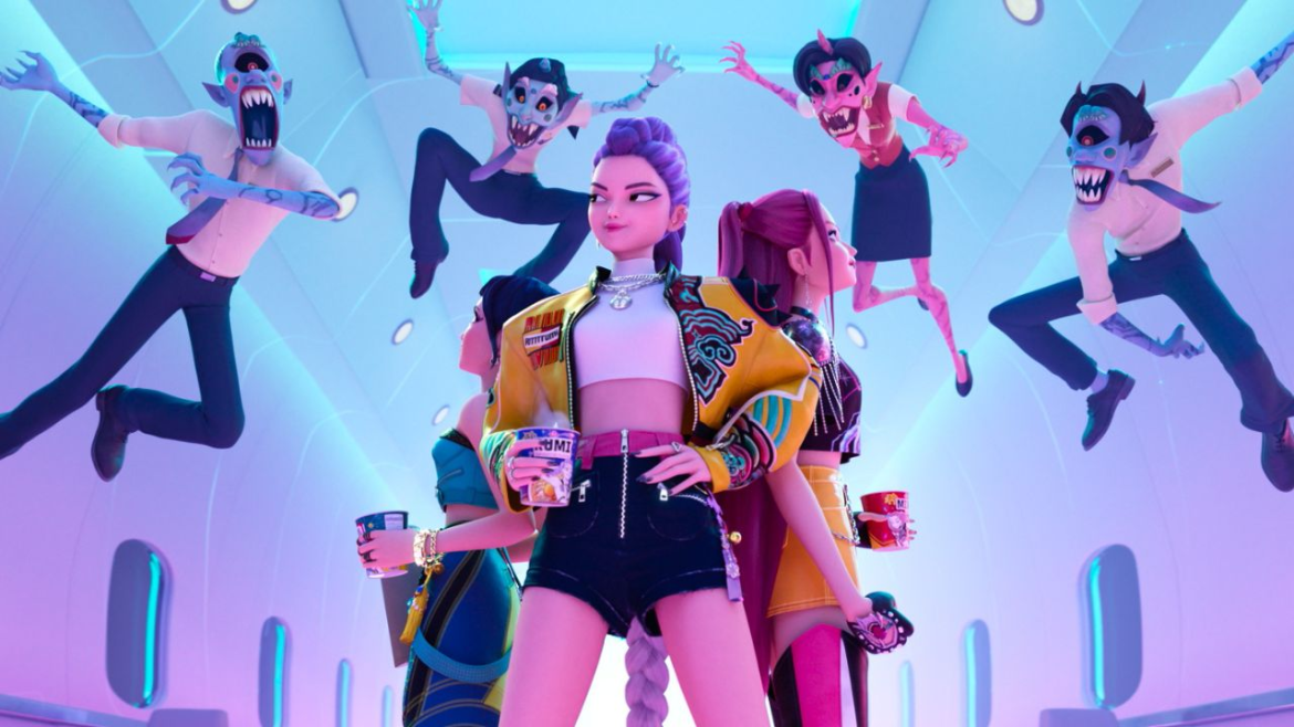 A imagem mostra um grupo de personagens animados em um ambiente futurista e estilizado — parece o interior de uma nave espacial com painéis brilhantes e design moderno. No centro, há uma figura em destaque vestindo uma jaqueta amarela vibrante com estampas coloridas, top branco e shorts pretos. Ela segura um copo e transmite uma energia de liderança e atitude. Ao redor, outros personagens também com roupas chamativas e copos na mão, formando uma espécie de "esquadrão estiloso".